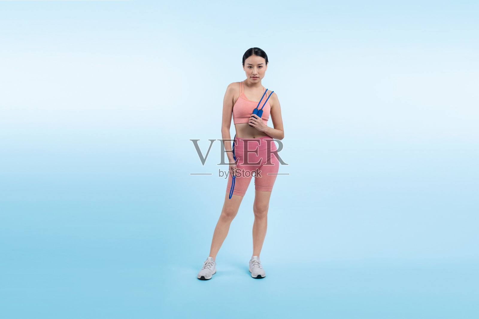 年轻充满活力的亚洲女性穿着运动服,正在跳绳。活力四射照片摄影图片