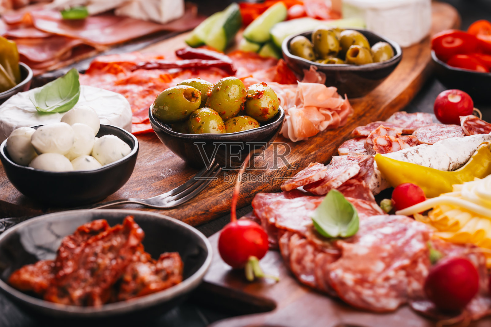 各种开胃菜和意大利冷盘拼盘放在木托盘上,肉类和奶酪的餐饮概念照片摄影图片