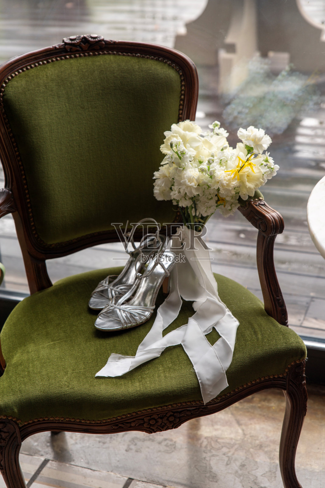 银色新娘高跟鞋与复古绿色椅子上的花束照片摄影图片