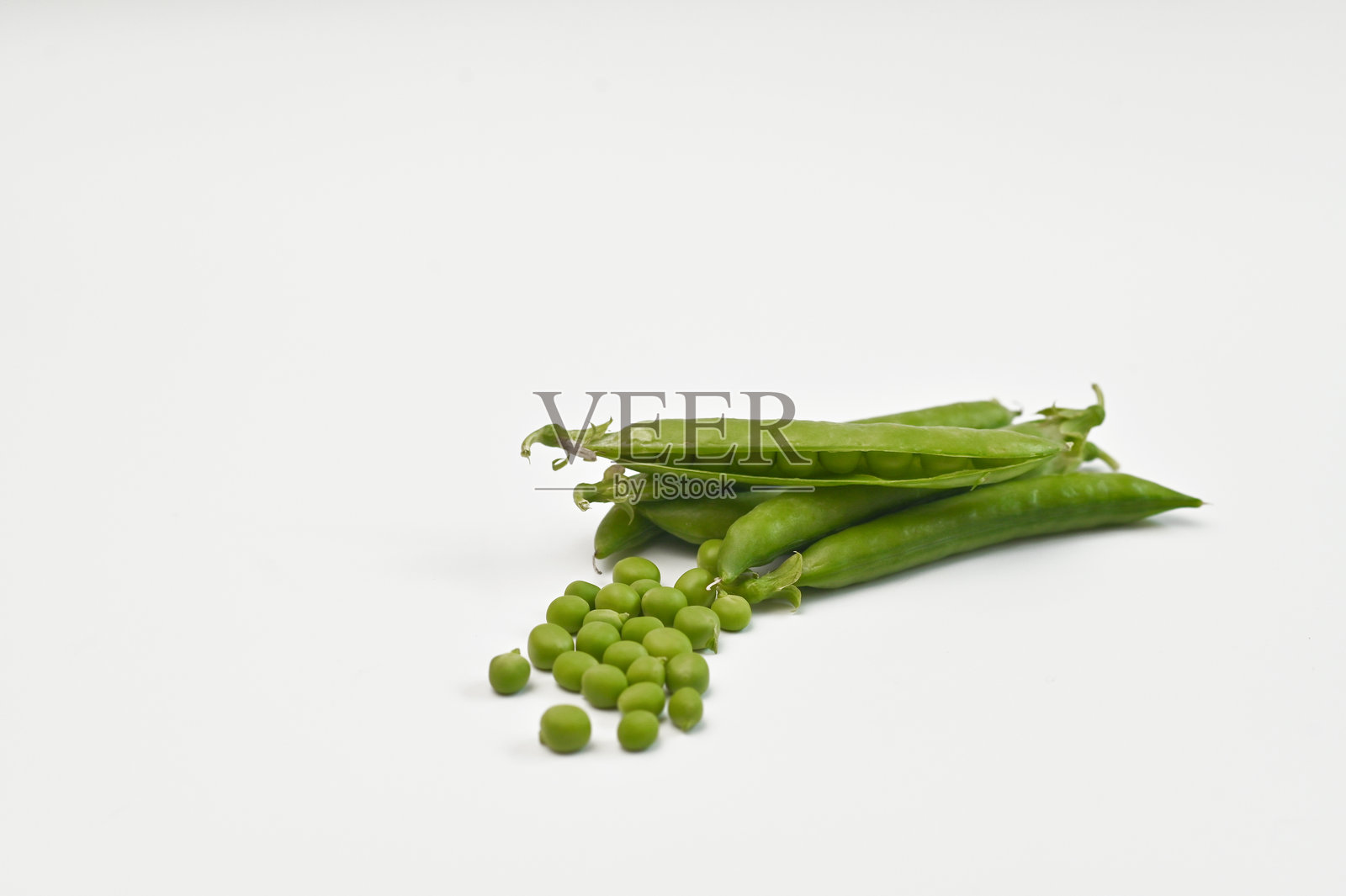 一荚豌豆。白色背景上的绿色圆点。照片摄影图片