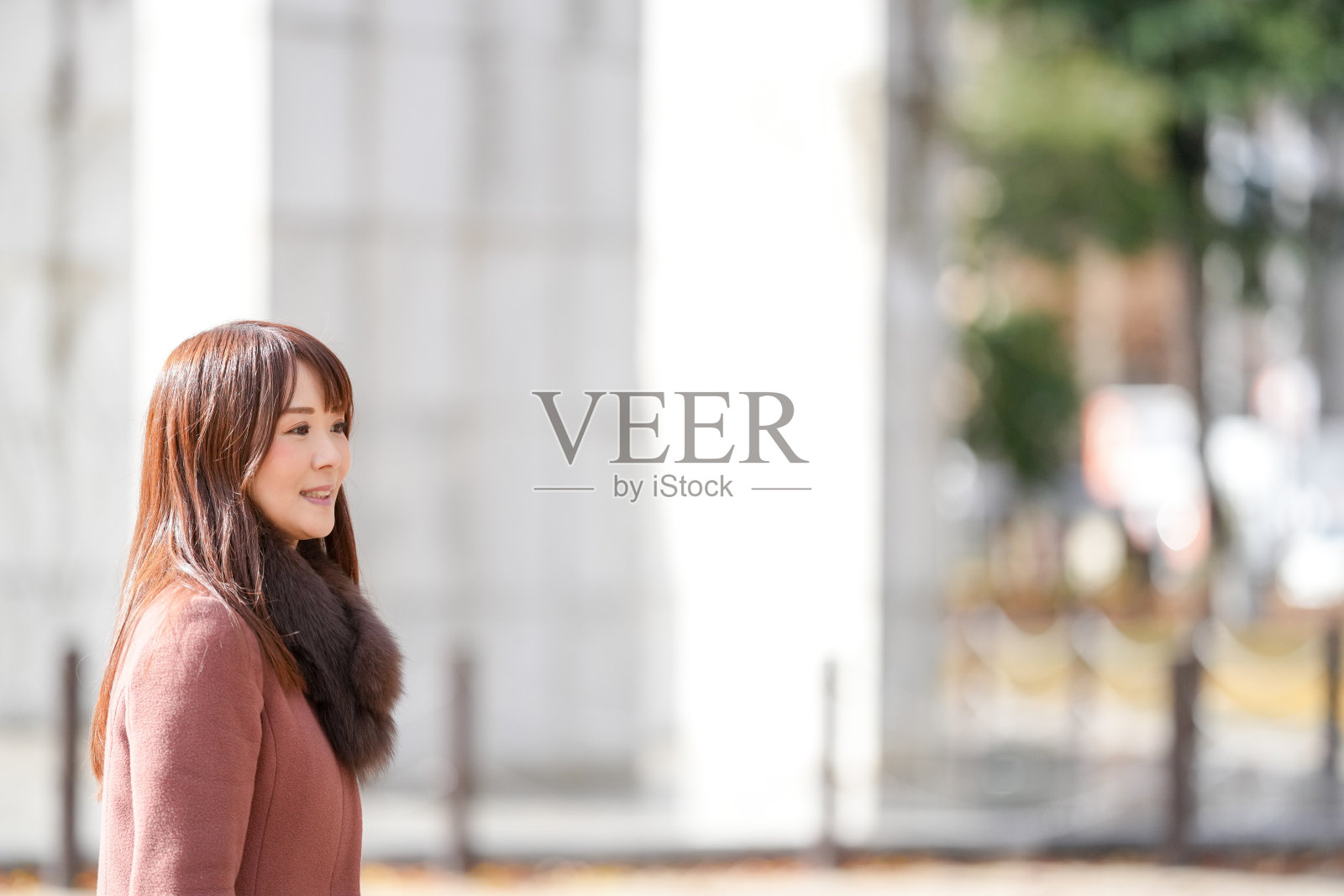 三十多岁长发女性在美丽的秋叶城市中漫步照片摄影图片