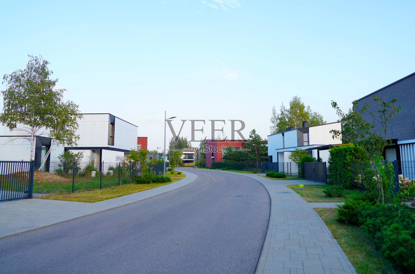 带有联排别墅的街道,位于封闭社区的沥青路旁。照片摄影图片