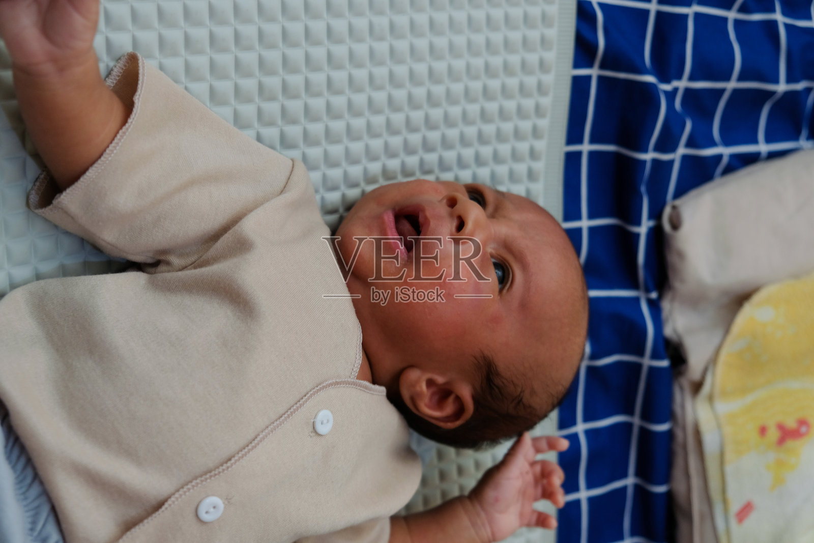 两个月大的新生儿在床垫上睡觉和玩耍。照片摄影图片