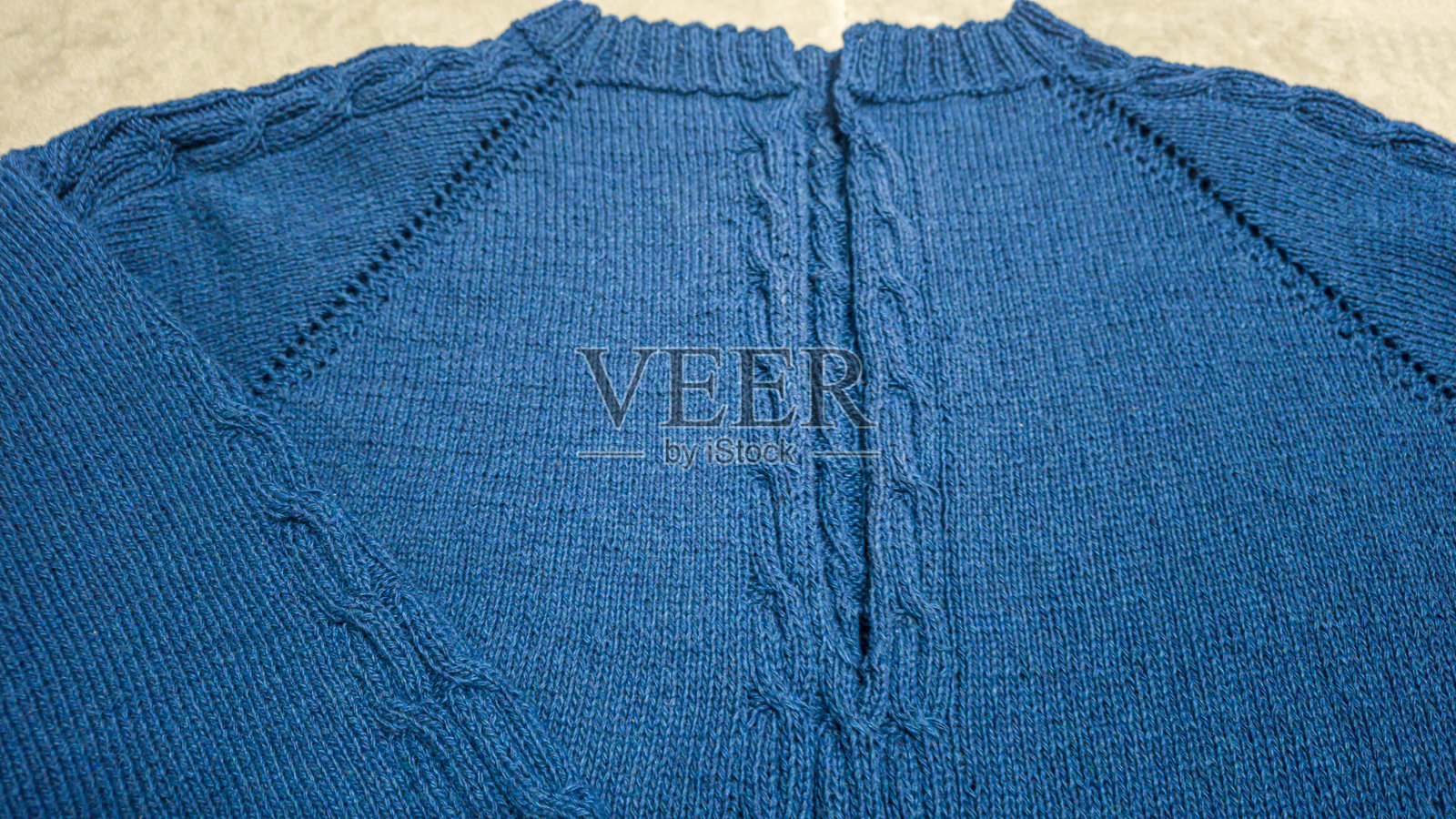 用蓝色线编织的产品。现成的手工女式毛衣。照片摄影图片