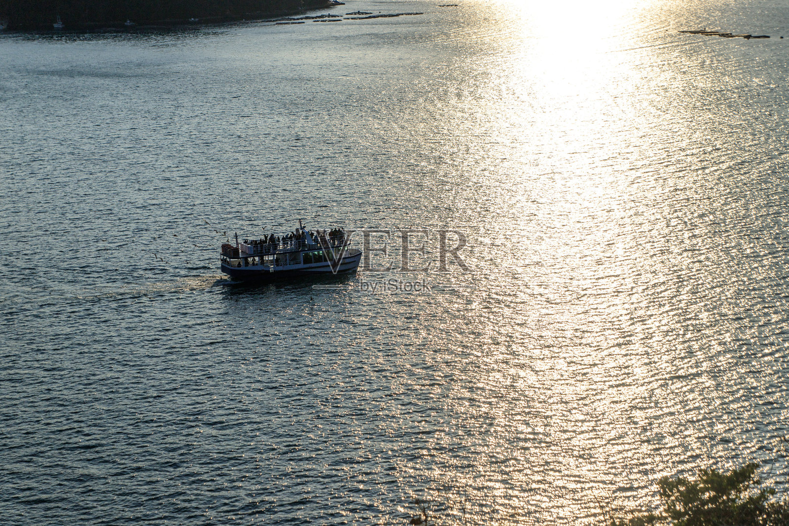 夕阳余晖洒在伊根湾,轮渡剪影映衬其间照片摄影图片