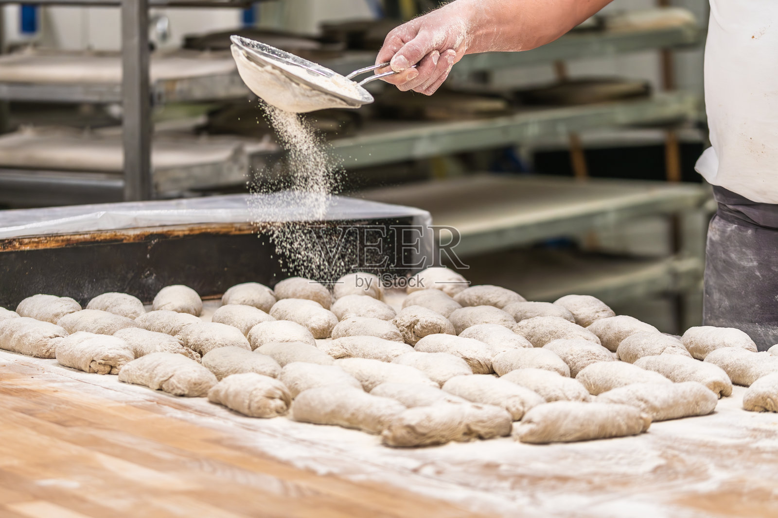 面包师的手在生面包上筛面粉照片摄影图片