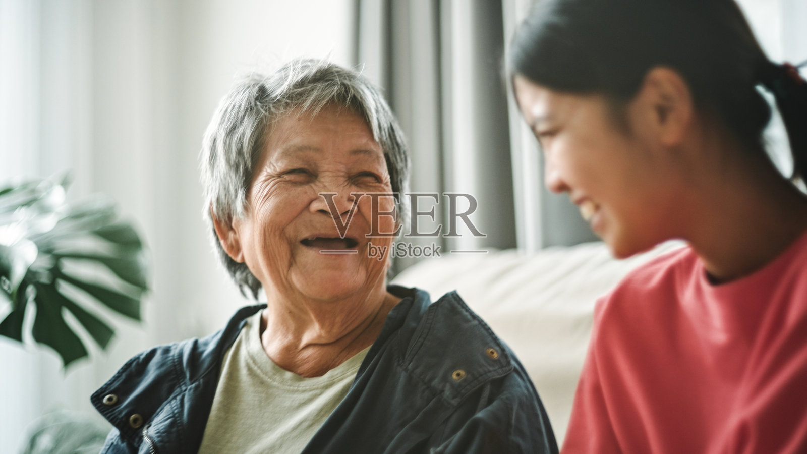 老年人与青少年在家中轻松交谈。照片摄影图片