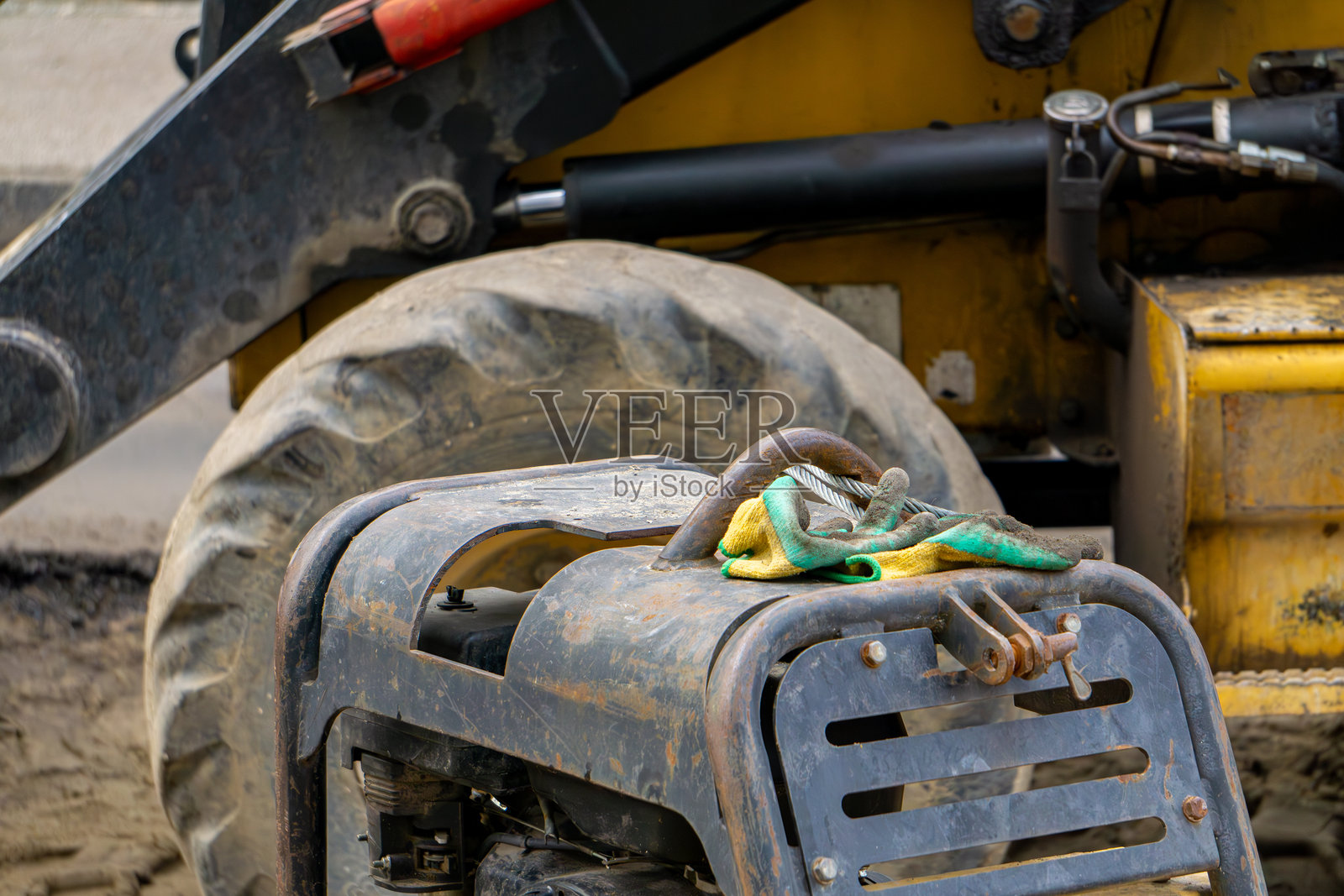 城市道路施工现场的建筑设备。压实机、土壤压实机、工作手套、黄色挖掘机。道路和土方工程。照片摄影图片