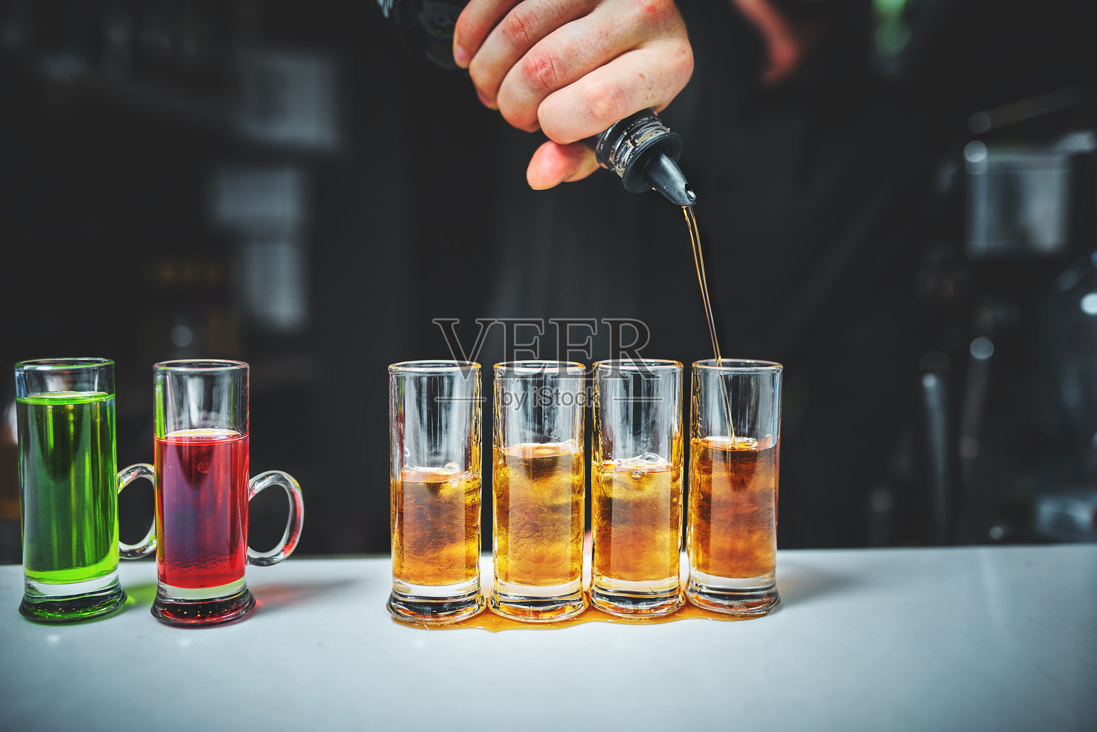 酒保正在将烈酒倒入酒杯中照片摄影图片