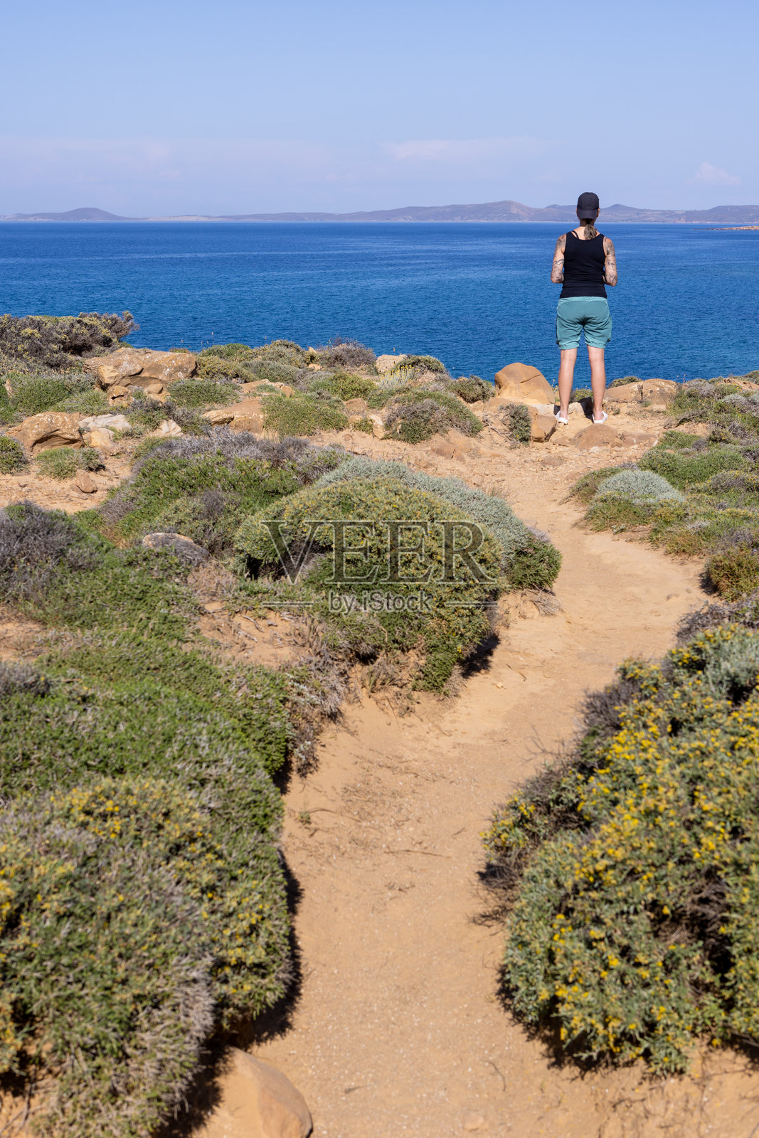 在荒野风景中观看海洋景色的女人照片摄影图片