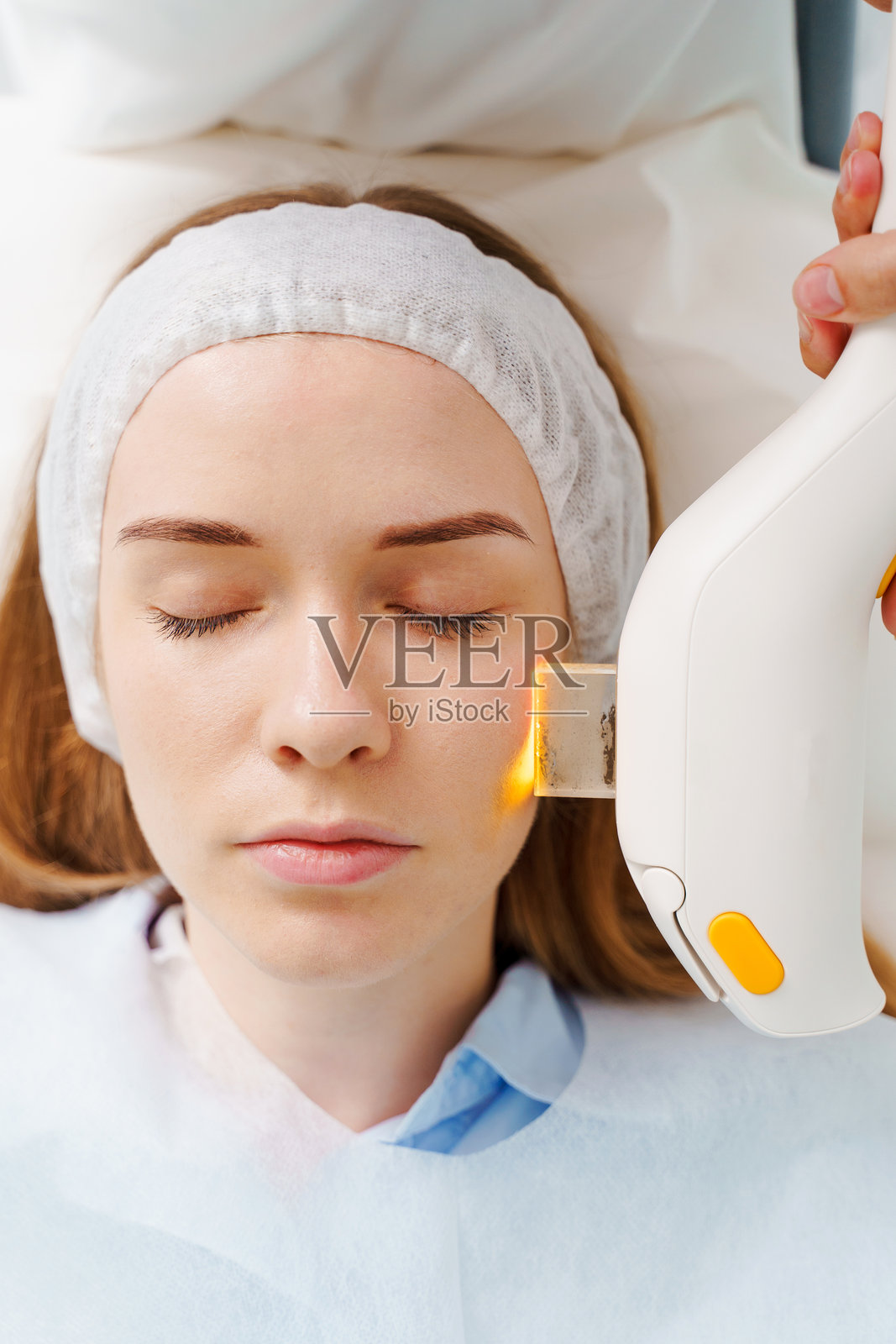 美容师进行IPL面部色素沉着治疗。医学中心的超声激光面部色素沉着治疗。皮肤色素沉着程序后的护理。照片摄影图片