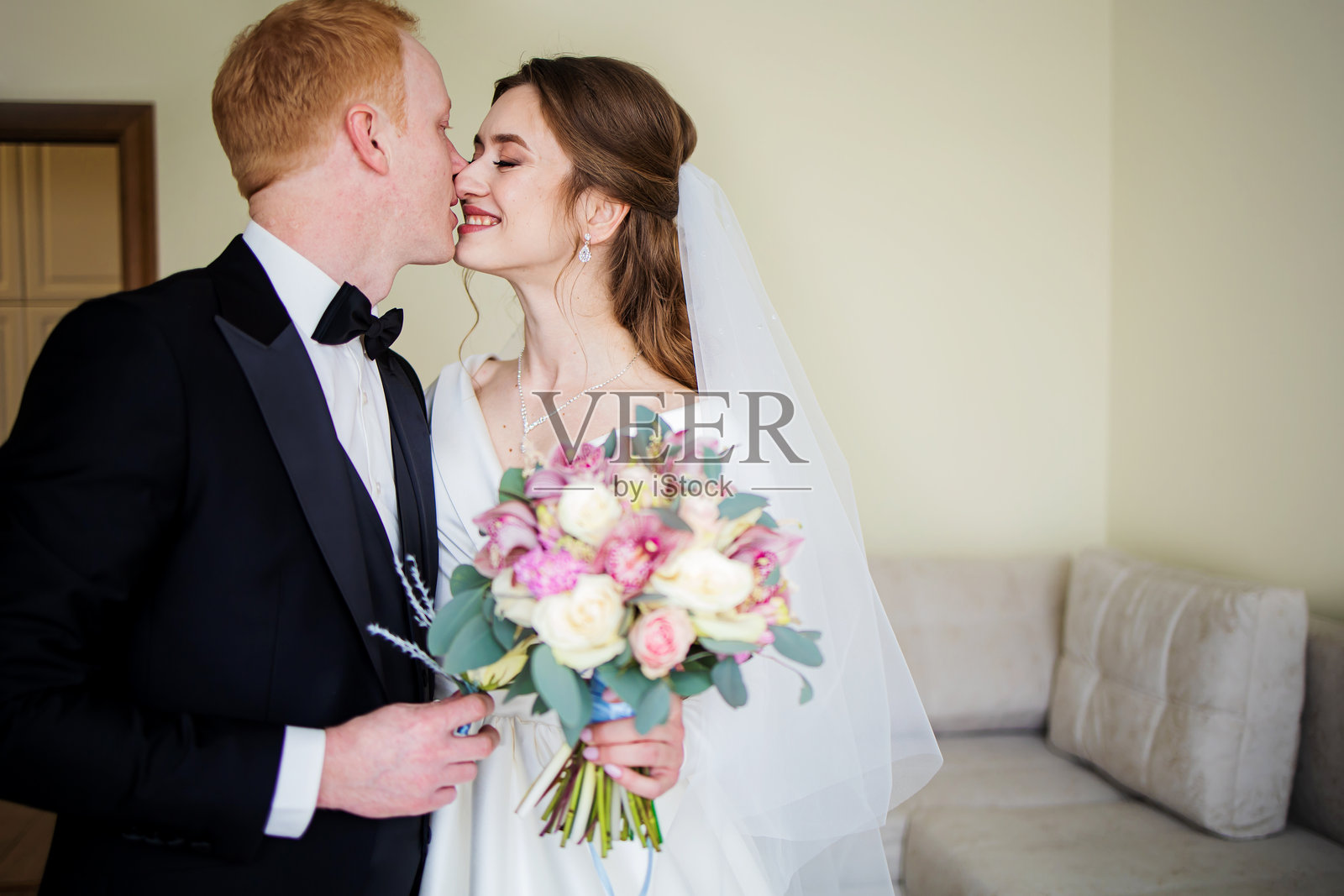 新娘手捧花束亲吻新郎的肖像照片摄影图片