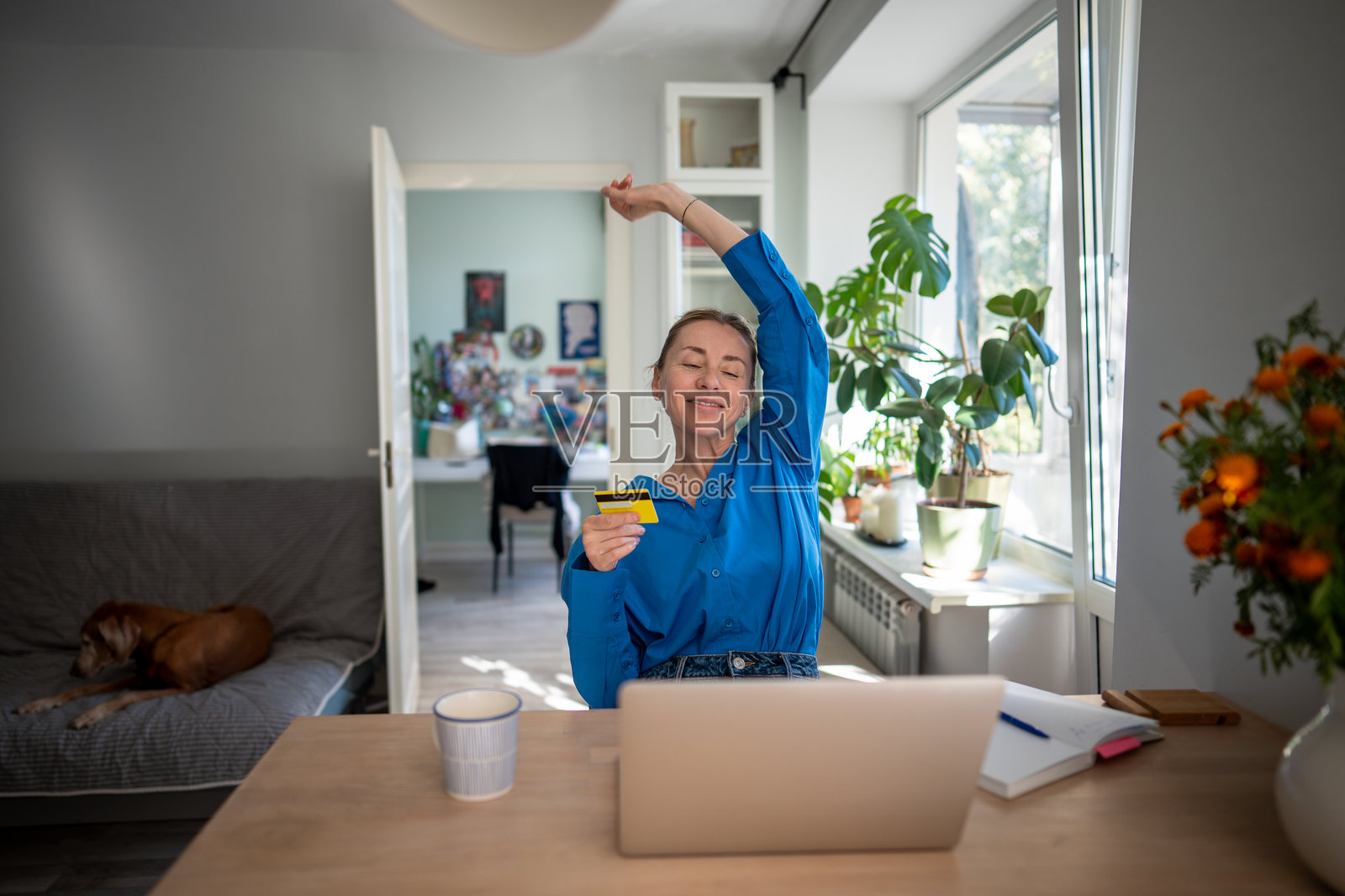 快乐的女性愉悦地伸展,享受便捷的在线预订和网购应用。照片摄影图片