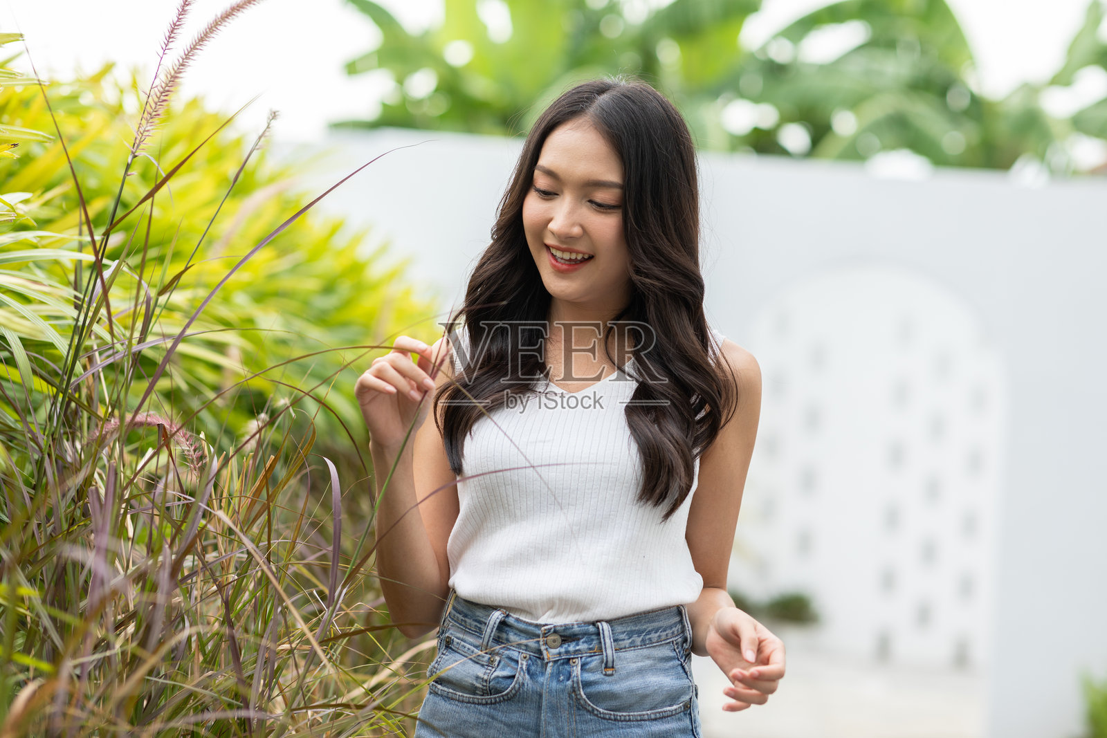 美丽的亚洲年轻女性微笑且充满活力。自信可爱的女性放松地看着镜头,享受健康的生活,感受美好时刻和积极的情绪。快乐的女性享受她的生活理念。照片摄影图片