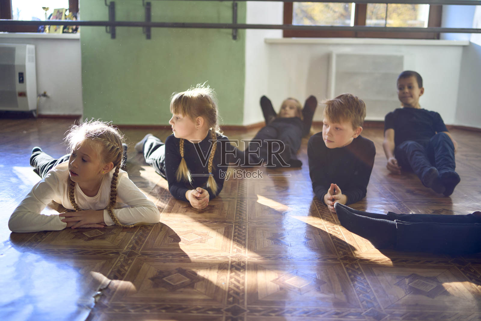 一群青少年在表演课上模仿动物,进行四足行走的老师任务。照片摄影图片