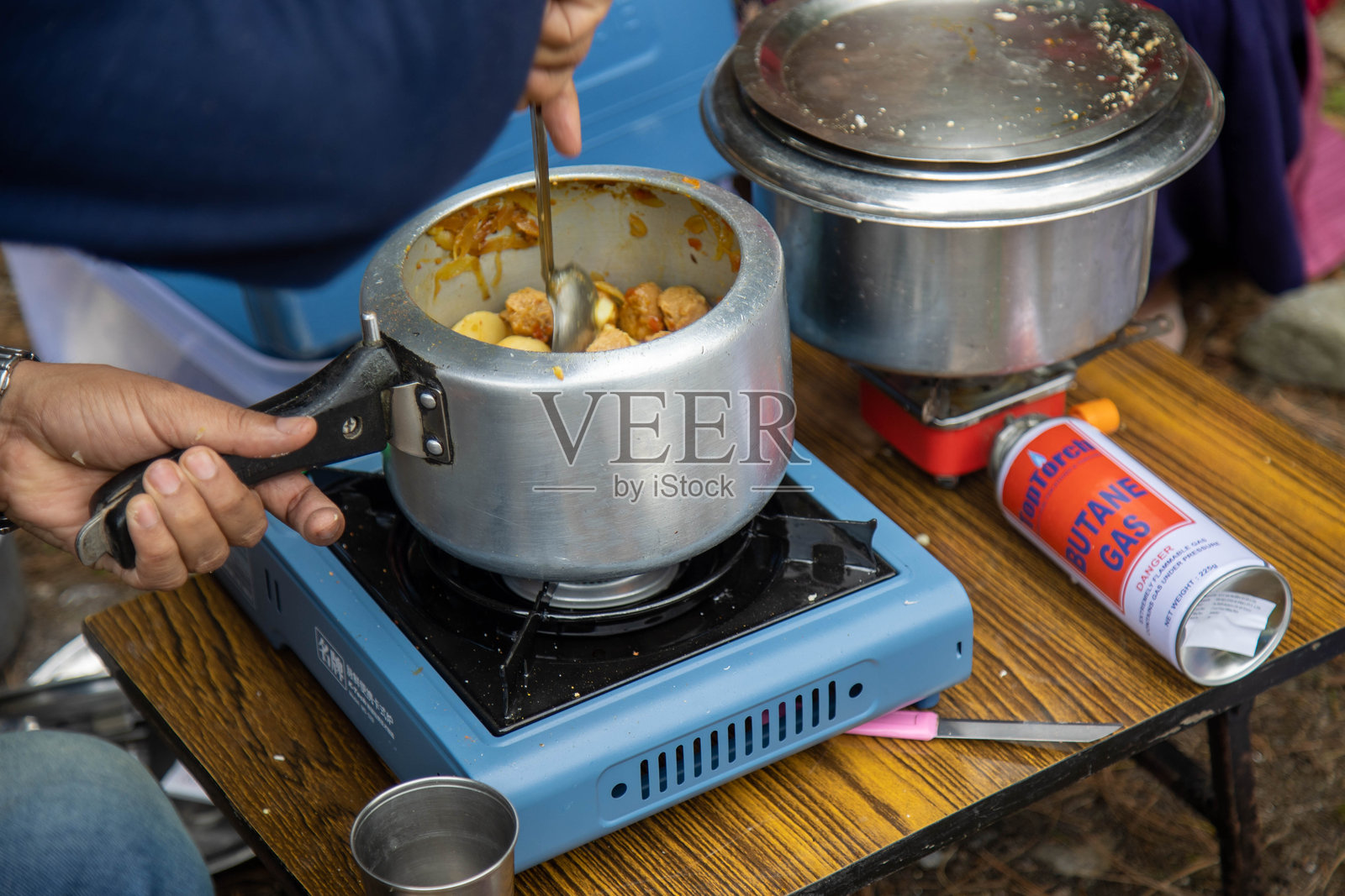 户外使用便携炉具和新鲜食材进行露营烹饪照片摄影图片