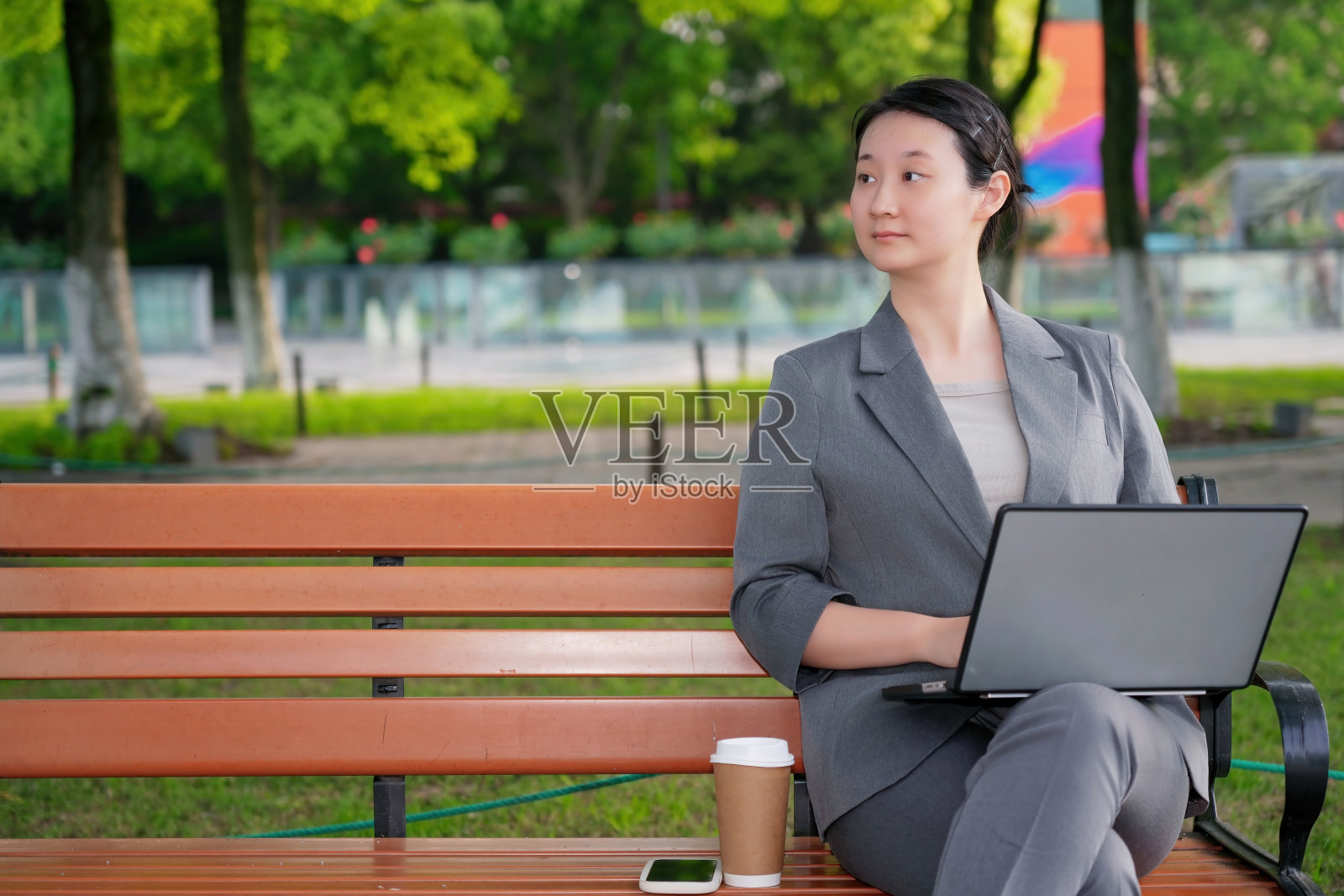 在公园环境中使用笔记本电脑工作的职业女性照片摄影图片