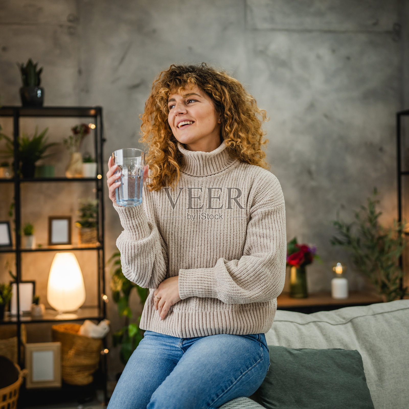 卷发女性在家中手持水杯享受时光照片摄影图片