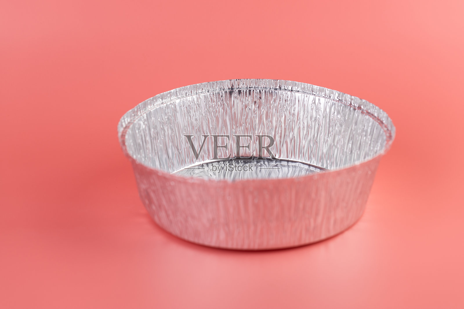 在柔和的粉色背景上,摆放着新的厨房铝箔圆形烘焙模具,现代科技带来厨房的清洁与实用,防洪系统设计。照片摄影图片