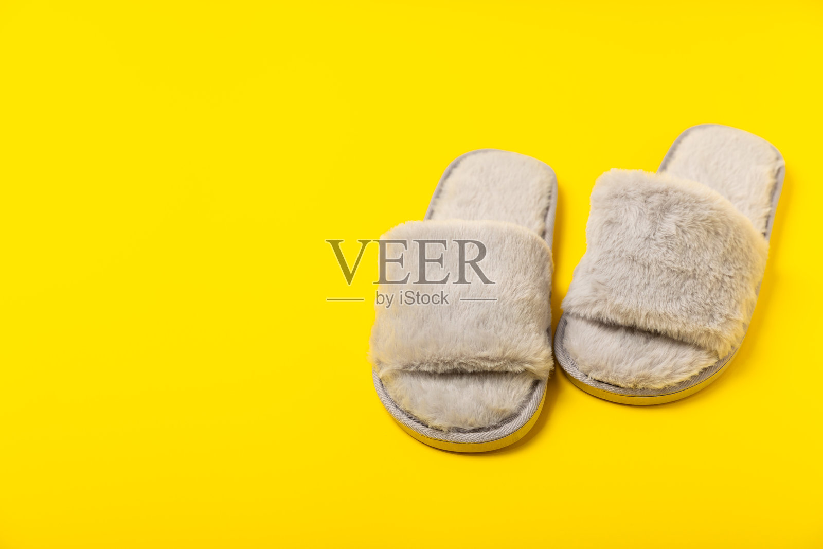 柔软的拖鞋在明亮的背景上,特写。家居拖鞋。舒适的家用鞋。足部护理概念。家庭舒适。留白空间。照片摄影图片