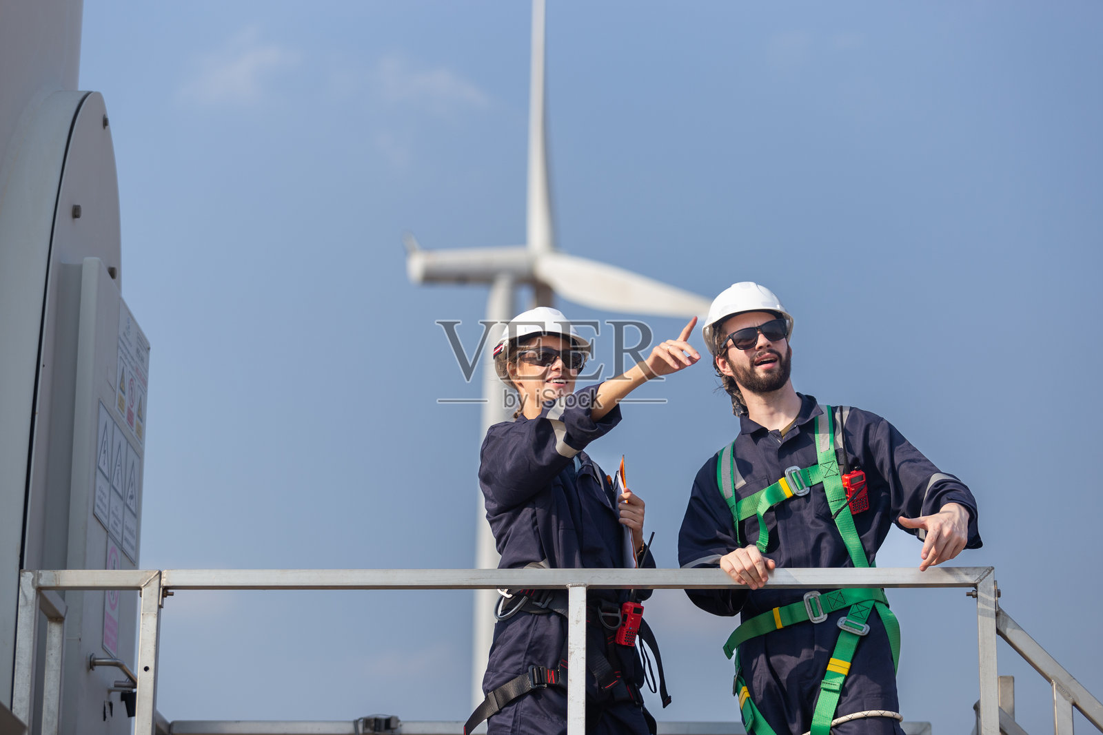 团队工程师风力涡轮机工人安全制服调查讨论运营规划风电场清洁能源。替代技术保护环境减少全球变暖问题。照片摄影图片