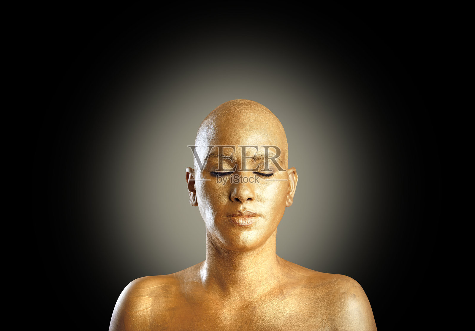 在黑色背景前冥想的美丽女性身上涂有金色身体油彩照片摄影图片