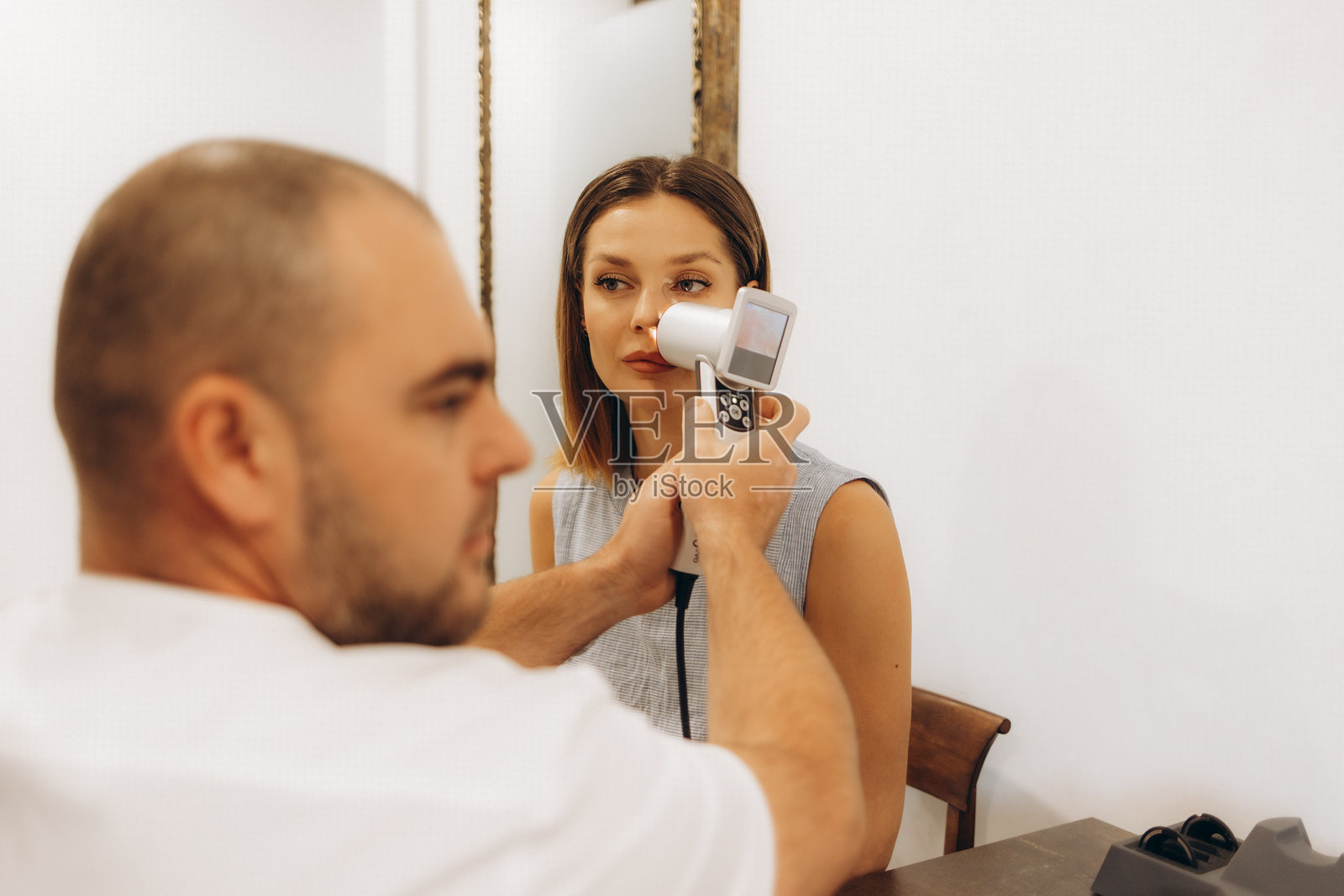 皮肤科医生使用皮肤镜检查美容院客户的面部皮肤。皮肤镜检查。文本空白处。照片摄影图片