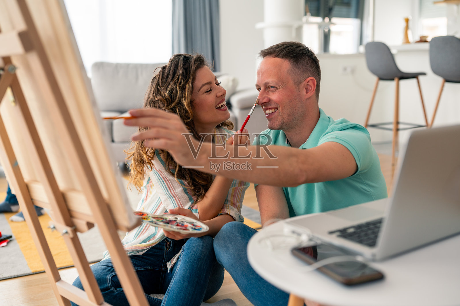 中年伴侣在家中创意绘画时共享欢笑照片摄影图片