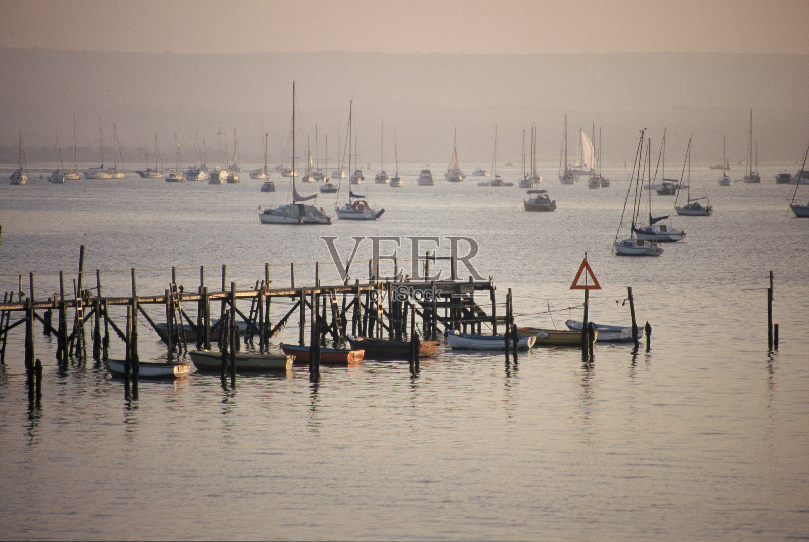在英国多塞特郡的普尔,日落时分停泊的帆船和游艇照片摄影图片