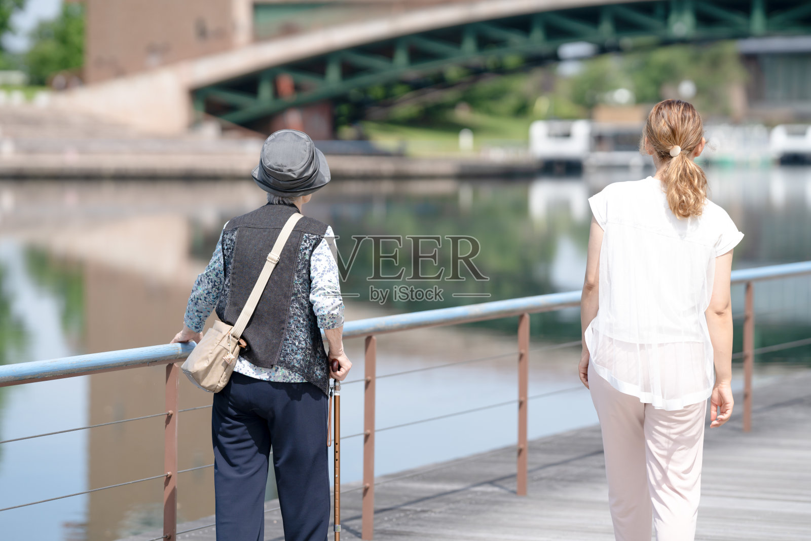 富山县一座气氛宜人的公园,公园内有运河。一位九十多岁的老奶奶和一位三十多岁的日本女性正在公园里散步。照片摄影图片