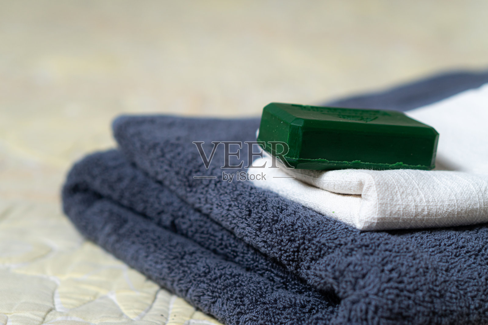 整齐叠放的毛巾与绿色肥皂照片摄影图片