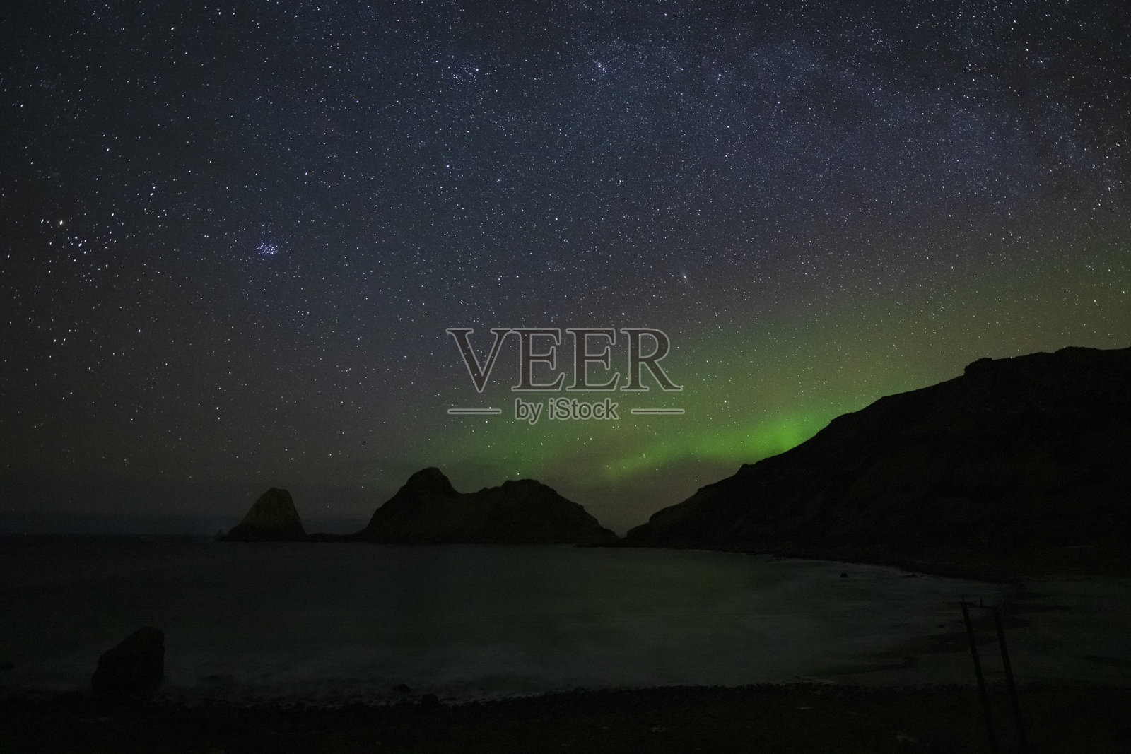 挪威北部尼克瓦格海滩上星空璀璨,微弱的北极光在闪烁照片摄影图片