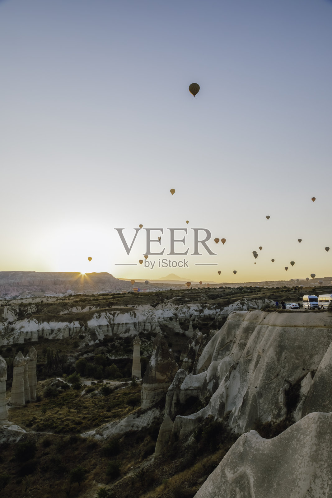 热气球飞越独特的岩石 formations,卡帕多奇亚的日出照片摄影图片