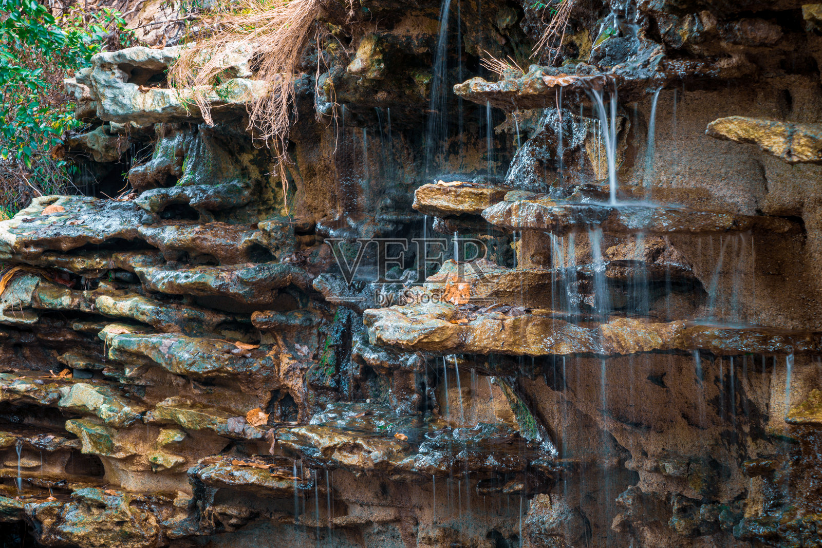 宁静的瀑布从岩层上倾泻而下照片摄影图片