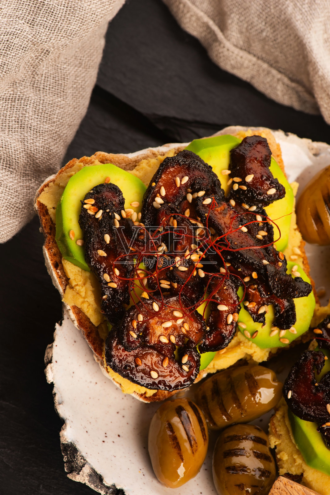 美味的三明治,配有鳄梨、鹰嘴豆泥和焦糖香菇照片摄影图片