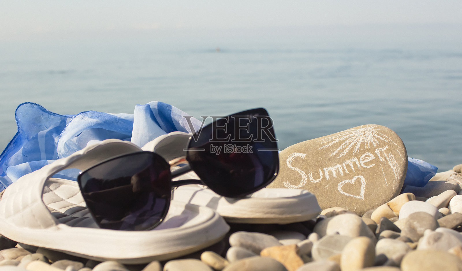 阳光明媚的日子里,黑色太阳镜特写在卵石海滩上。夏季假期的概念。照片摄影图片