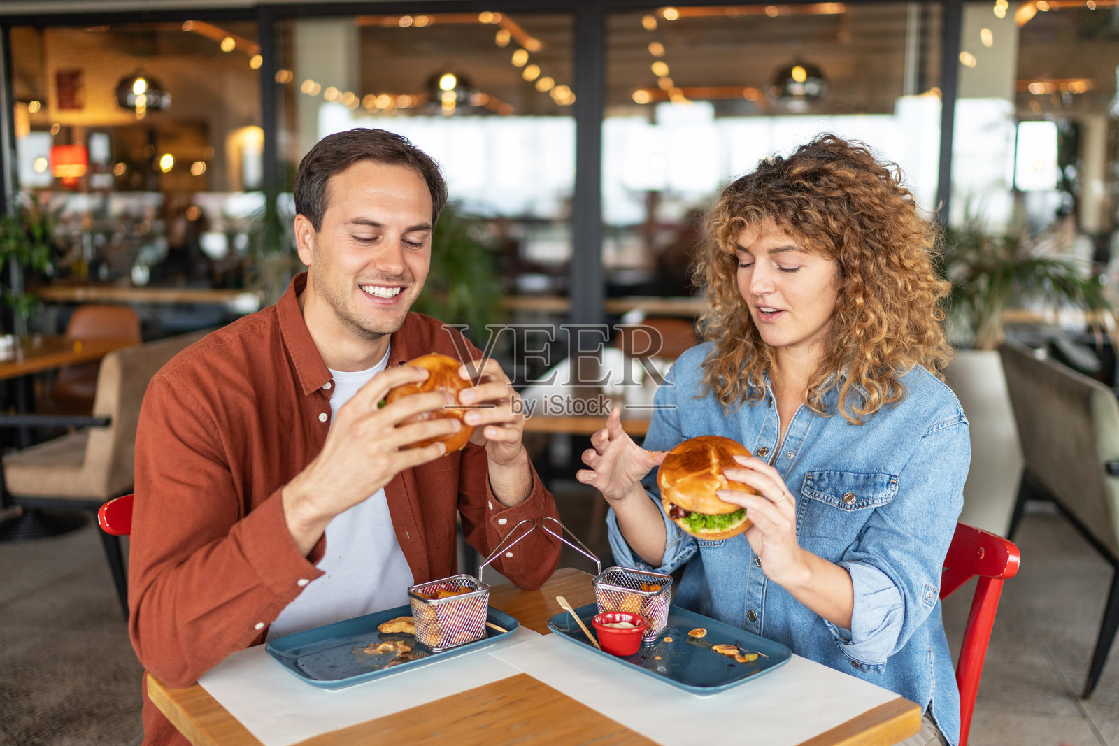 年轻情侣欢笑着享受汉堡照片摄影图片