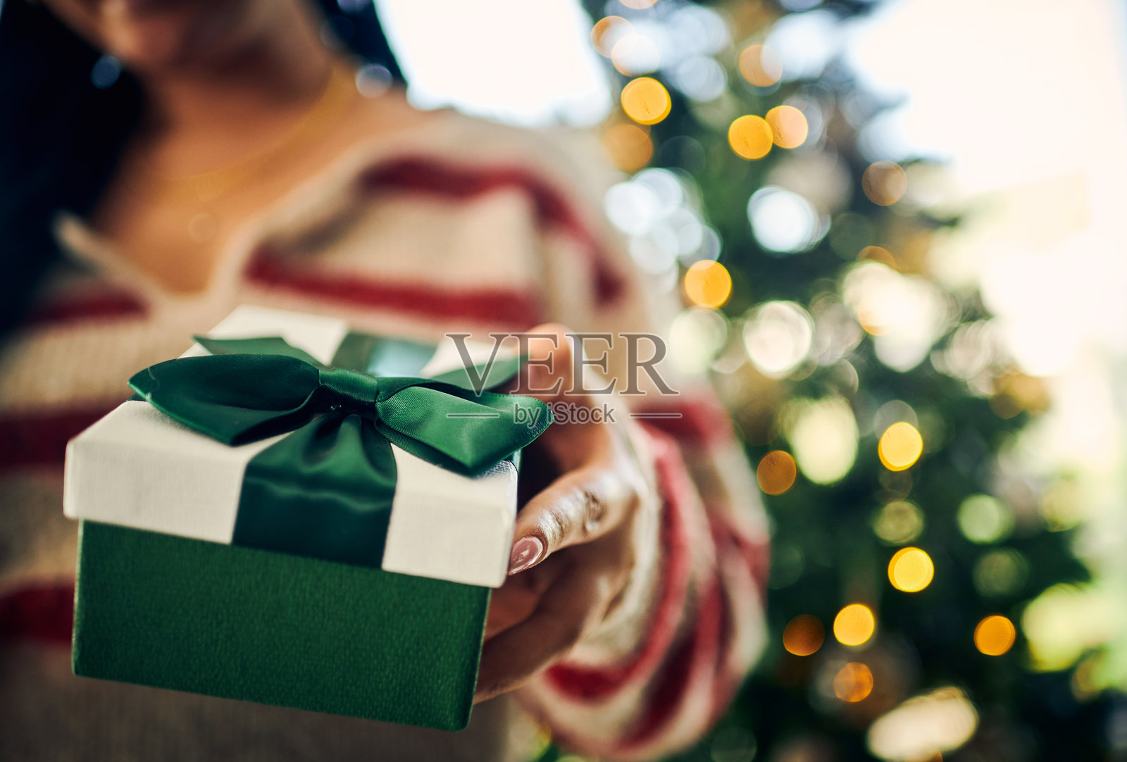 在圣诞树前展示礼物的女人照片摄影图片