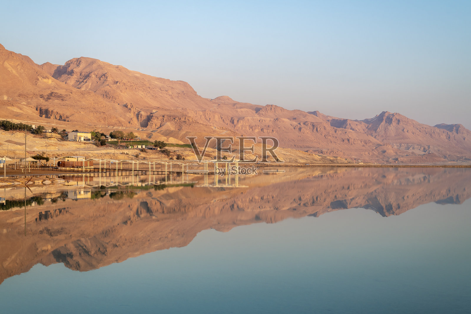 犹太沙漠的山脉映照在死海中。照片摄影图片