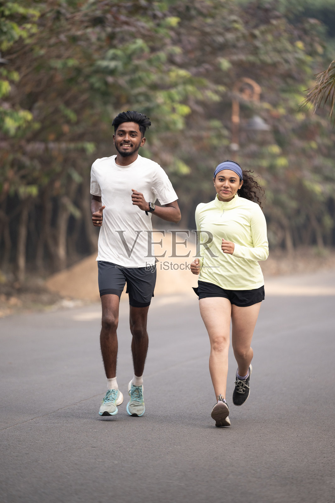 年轻健康的情侣在风景优美的道路上慢跑照片摄影图片