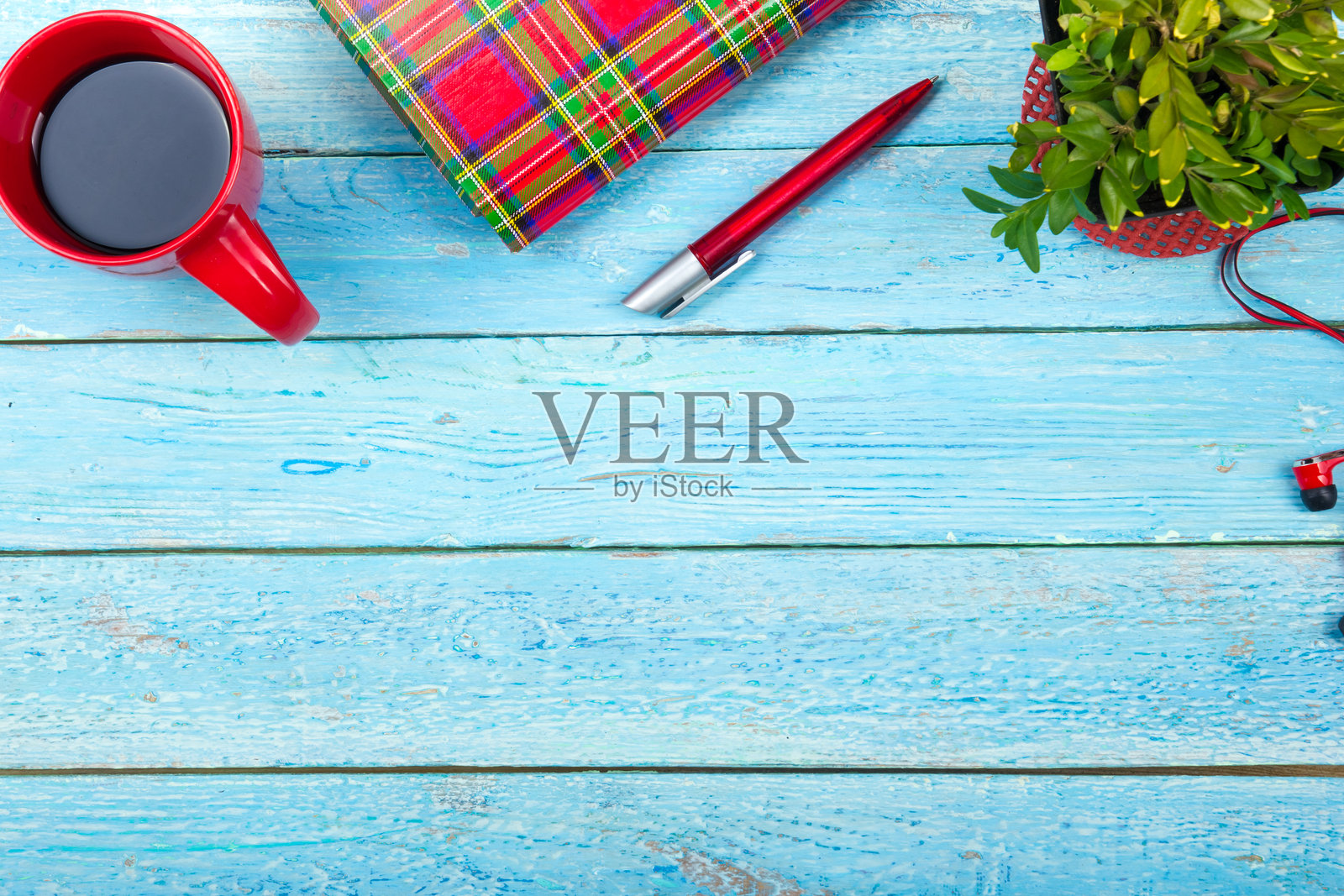 蓝色的办公桌子上有电脑,钢笔和一杯咖啡,很多东西。带复制空间的俯视图。照片摄影图片