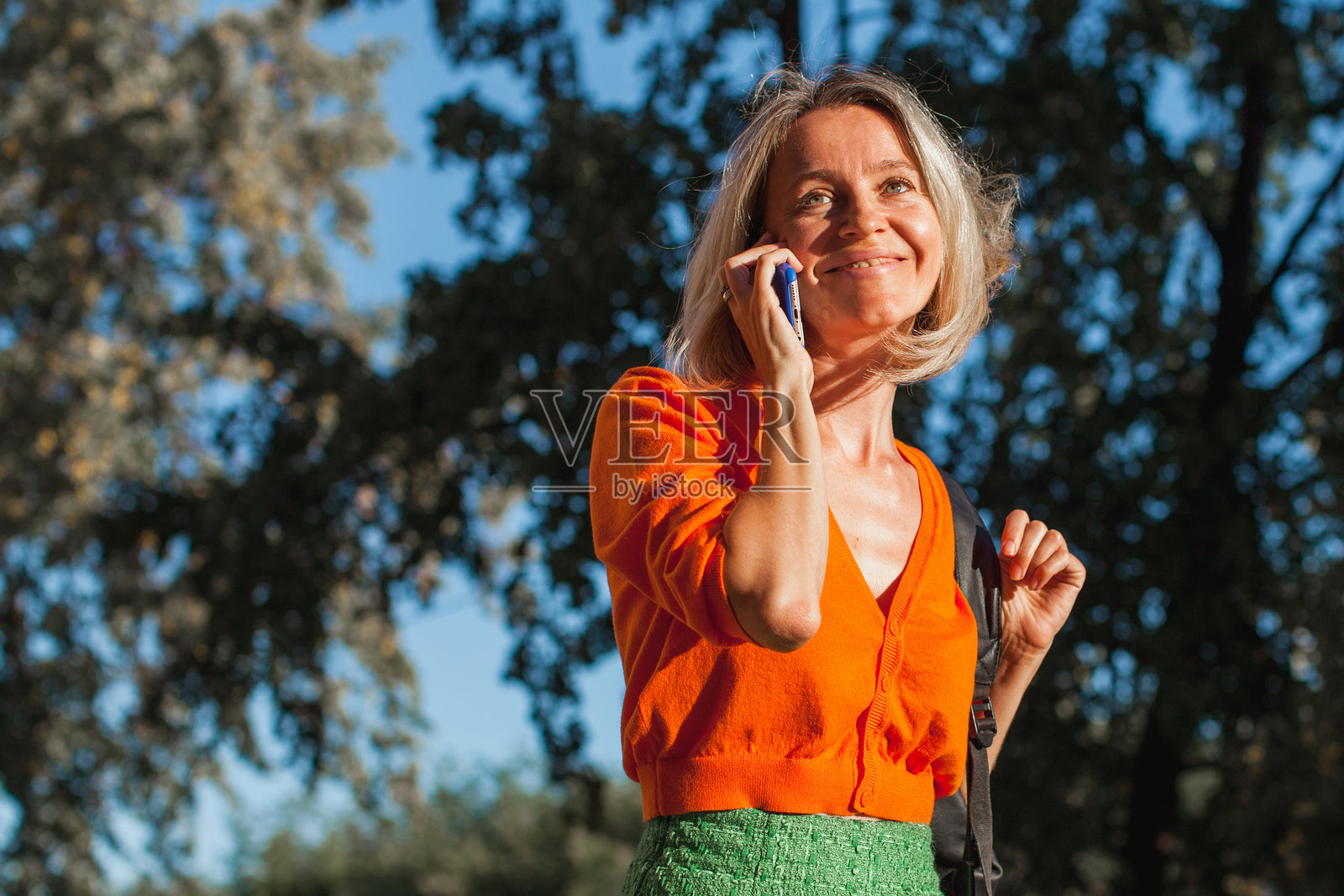 快乐的中年女性在城市户外使用手机照片摄影图片
