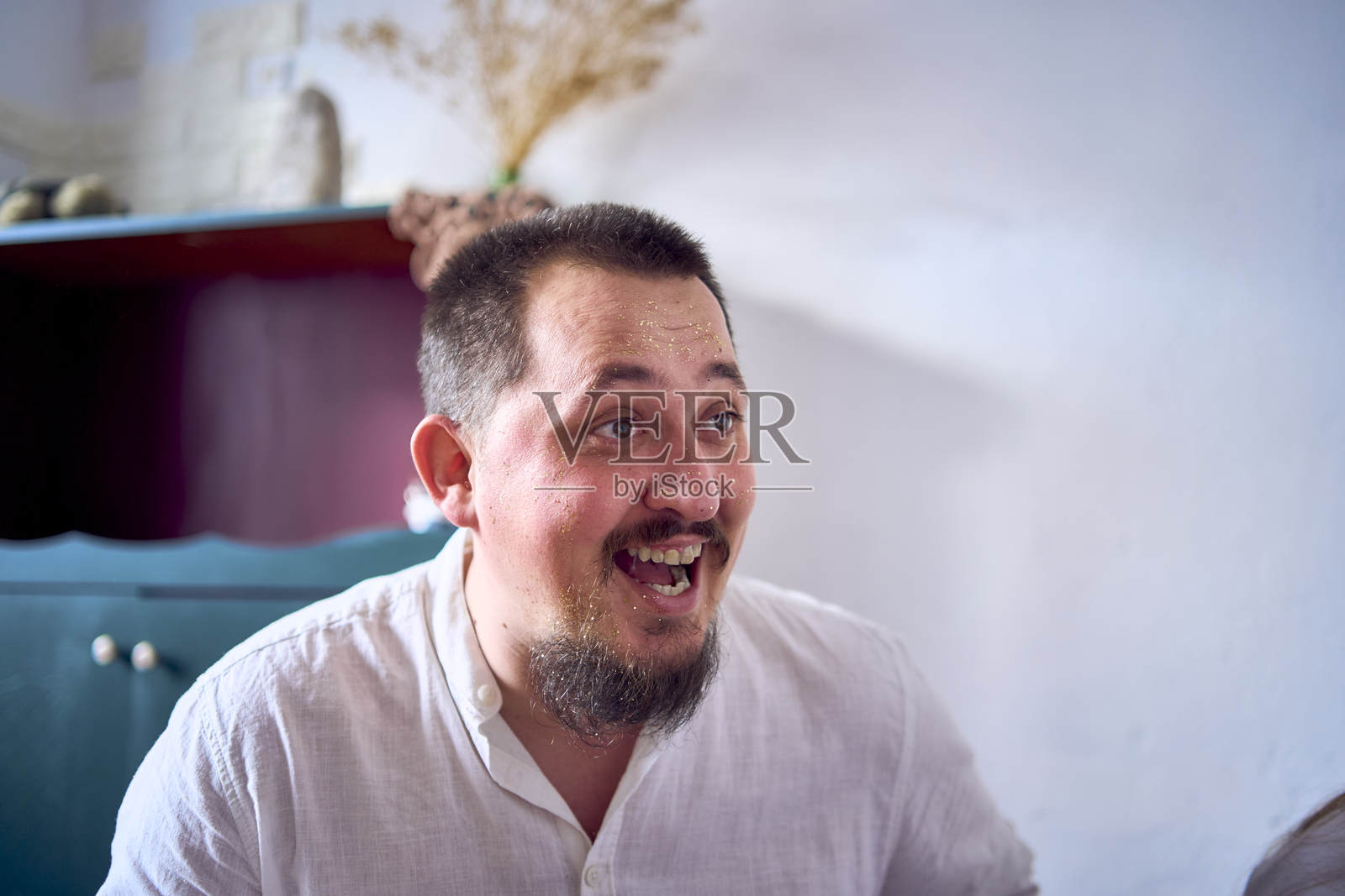 一家人在家里的圣诞派对上互相用金色闪粉画脸。照片摄影图片