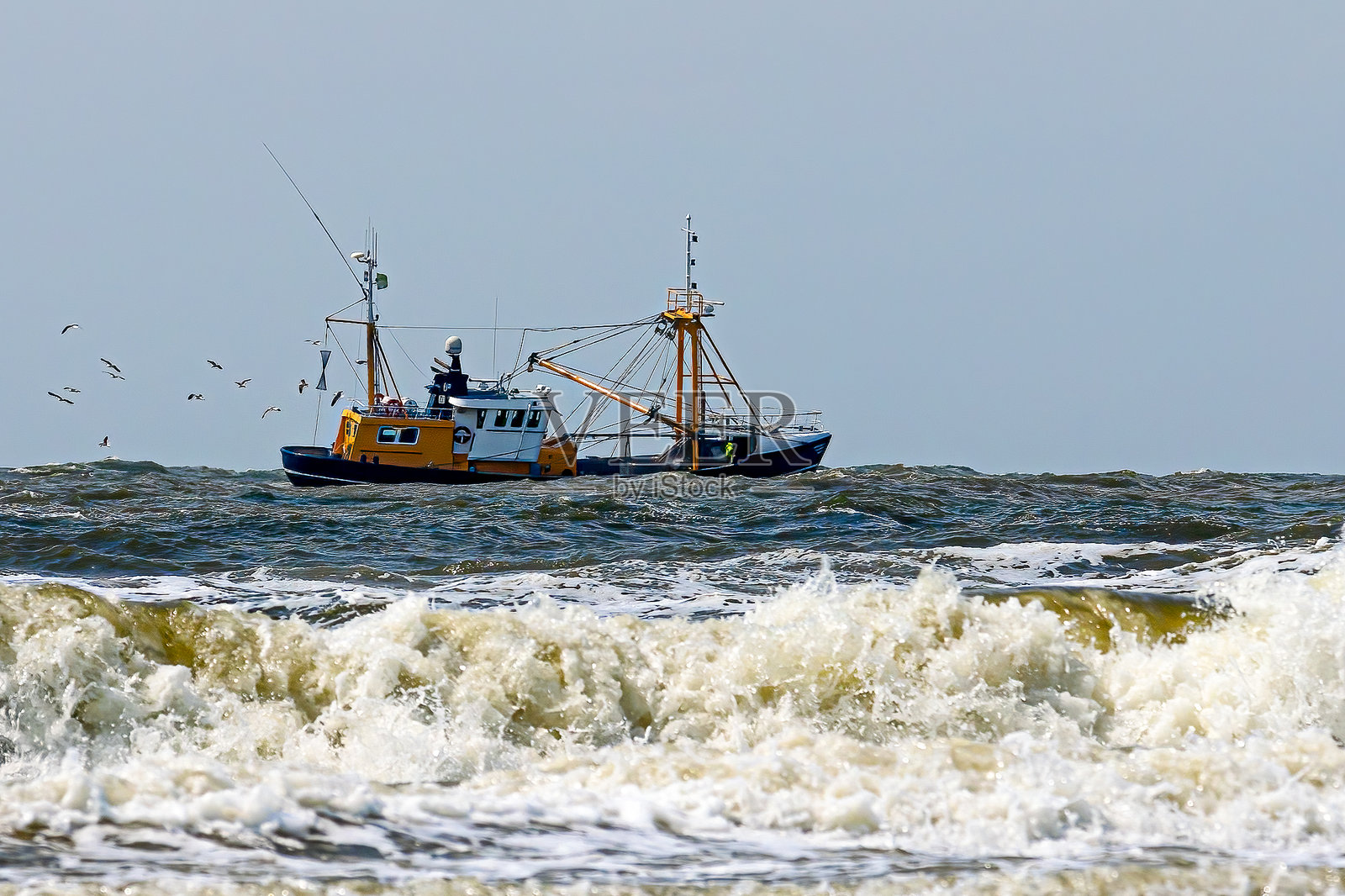 前景中有飞溅浪花的渔船照片摄影图片