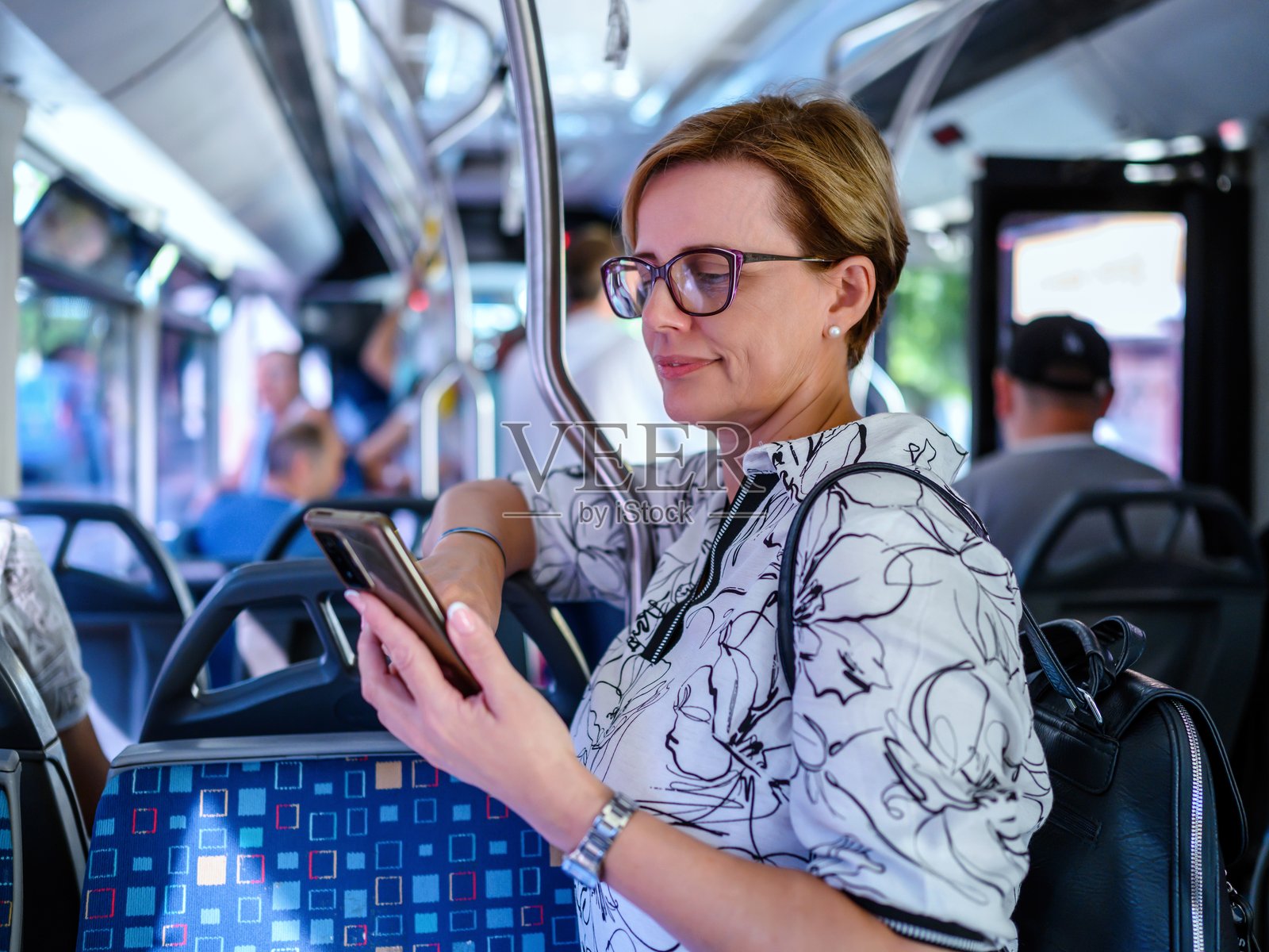 女性在公共交通工具上使用手机旅行照片摄影图片