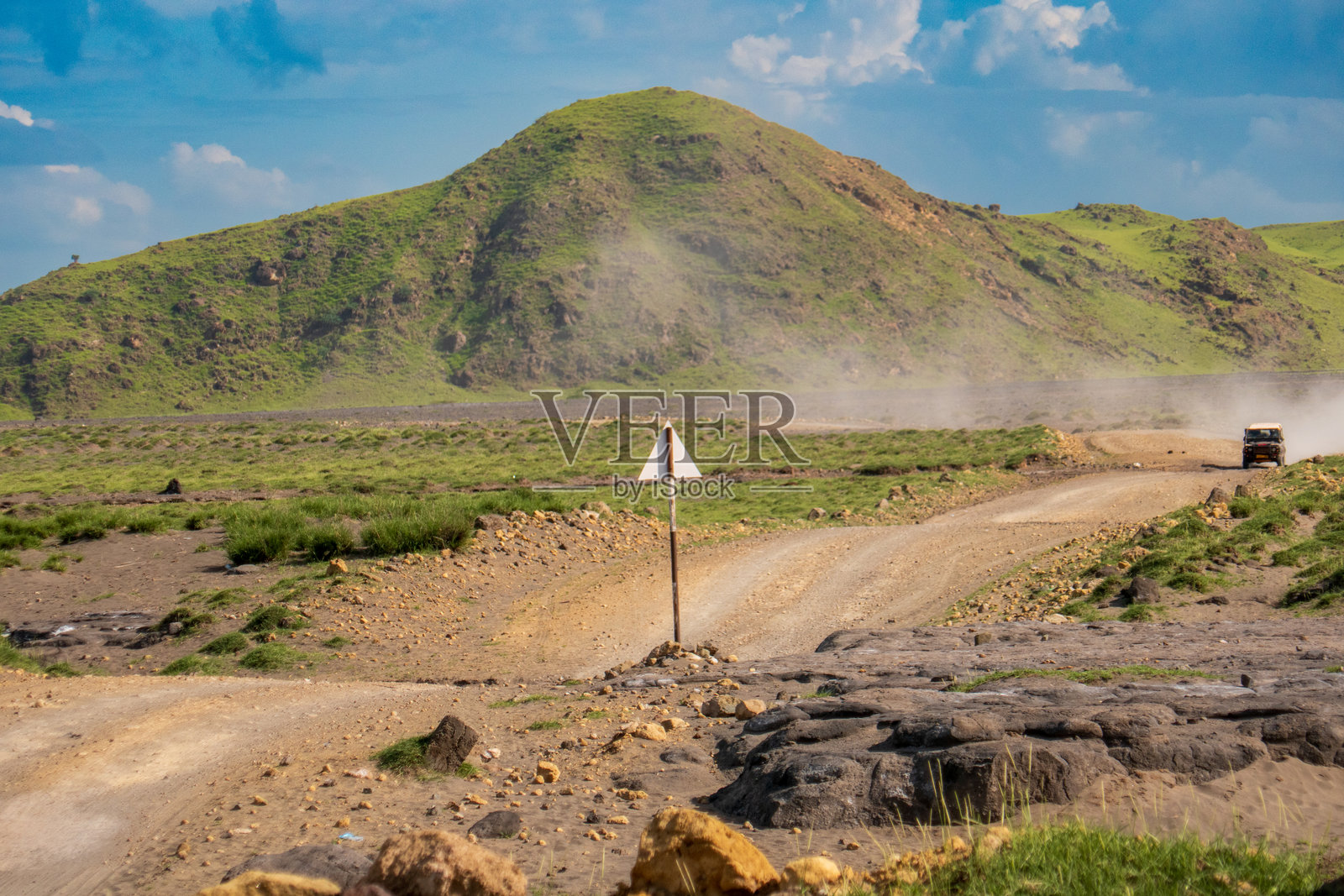 坦桑尼亚奥尔东约伦盖山脉上的泥土路上行驶的越野车照片摄影图片