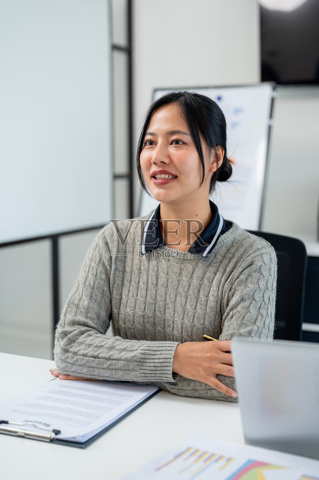 一位美丽的亚洲女商人认真倾听同事在会议上的演讲。照片摄影图片