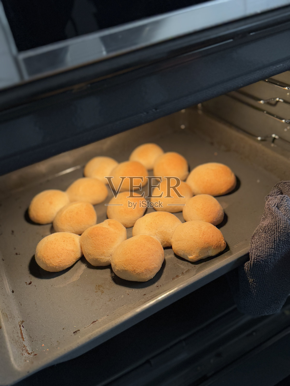 新鲜制作的面团球整齐排列在迷你烤盘上,准备放入烤箱烘烤。照片摄影图片