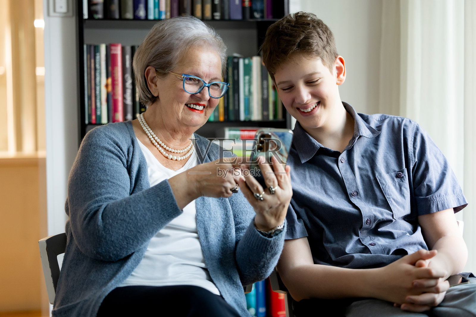 孙子在现代客厅教奶奶数字科技照片摄影图片