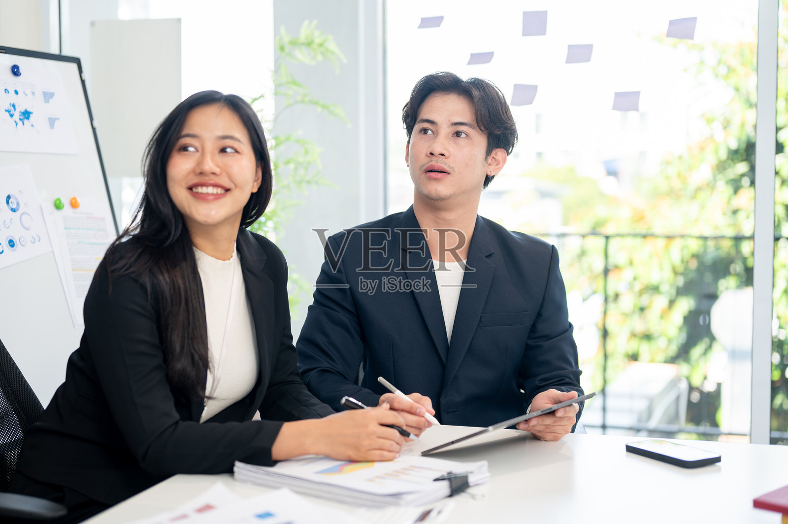 两位积极的亚洲商人在会议中专心听取演讲。照片摄影图片